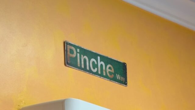 A white air conditioner mounted to a yellow wall